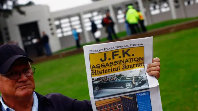 Turista segura jornal falando da mortemulta pixbet corinthiansJohn Kennedymulta pixbet corinthiansfrente à praça Dallas, nos EUA