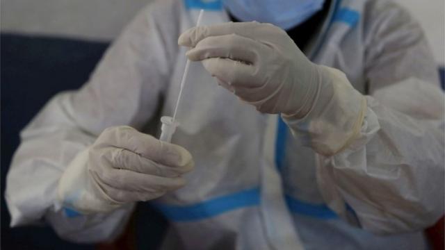 A paramedic conducts a Rapid Antigen test for COVID-19 of a Kashmiri man in Srinagar