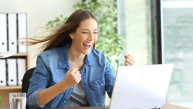 chica alegre usando computadora