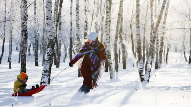 Una madre jugando con su hijo en la nieve