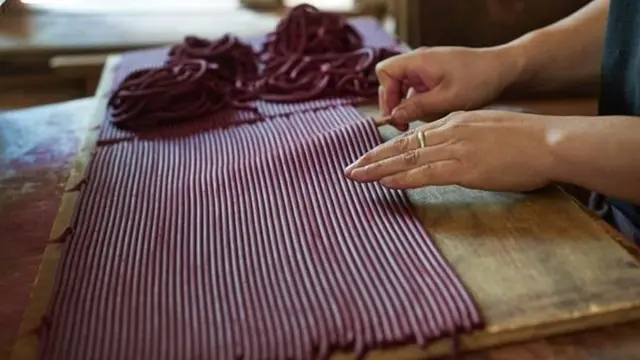 Une équipe d'ouvriers redresse puis coupe les bobines d'encens pour en faire des bâtonnets.
