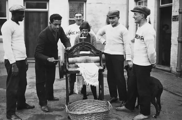 31st December 1926: Len Johnson British light-heavyweight boxing champion, helps with the mangling, his father is on the left. (Photo by Brooke/Topical Press Agency/Getty Images)