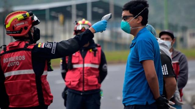 Des pompiers équipés de thermomètres patrouillent dans les rues de Quito, testant les gens pour la fièvre