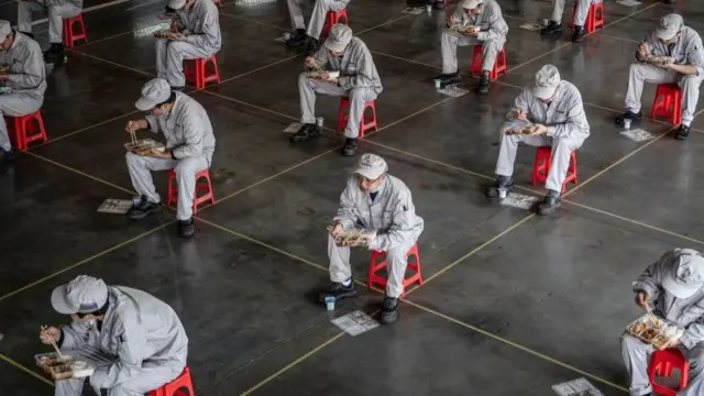 উহানের এক গাড়ি নির্মাণ কারাখানায় দুপুরের খাবার খাচ্ছেন শ্রমিকরা।