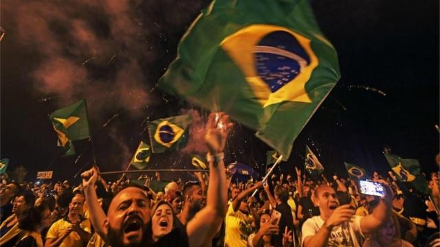 Supporters of far-right lawmaker and presidential candidate for the Social Liberal Party (PSL), Jair Bolsonaro, celebrate in Rio de Janeiro, after the former army captain won Brazil's presidential election, according to official results that gave him 55.7 percent of the vote, on October 28, 2018.