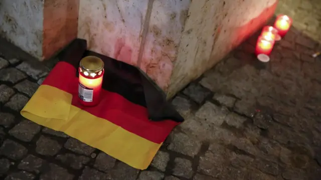 德国柏林，遇袭集市附近的一个广场上，有人点起了蜡烛并摆放了德国国旗。