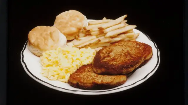 Refeição com batata frita, scones, ovo mexido e torradas