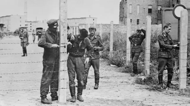 This picture from 14 August 1961 shows soldiers putting up a barbed wire barrier in preparation for the full construction of the Berlin Wall