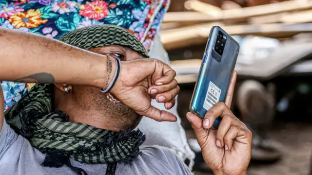 A member of the opposition uses his smartphone at base camp