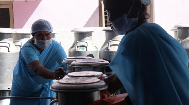 మహిళలు పాల డబ్బాలతో