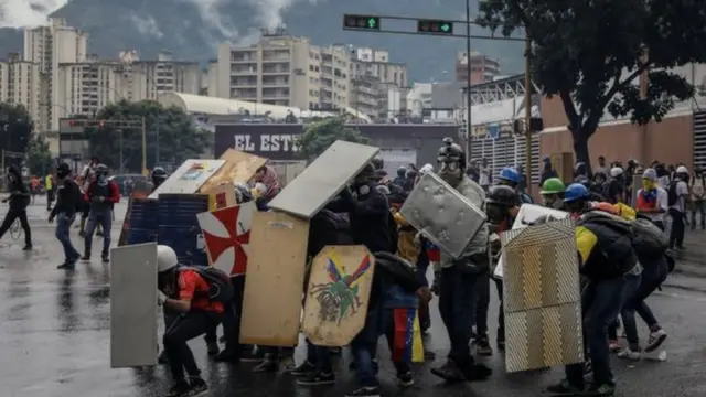 متظاهرون يحملون دروع