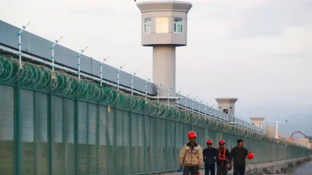 عمال أمام معسكر اعتقال