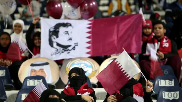 قطريون يحملون صورة أمير البلد