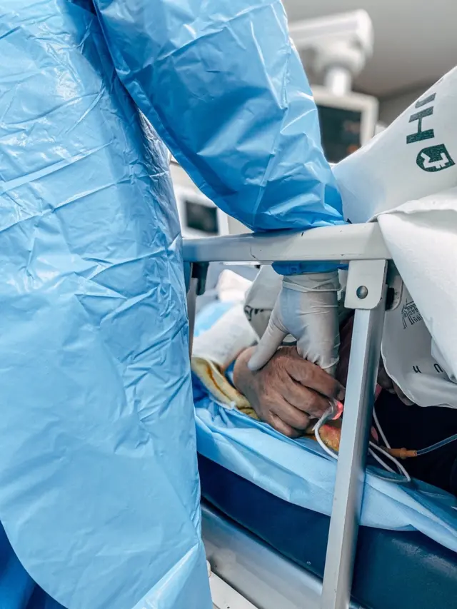 코로나 의심 증상으로 응급실을 찾은 할머니. 이강용 간호사는 "할머니가 많이 불안해하셔서 간호사 동료가 손을 잡아주고 있는 모습"이라고 말했다