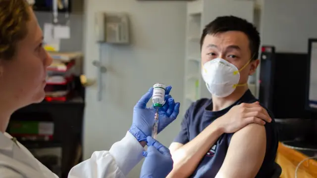 Homem sendo vacinado por médica