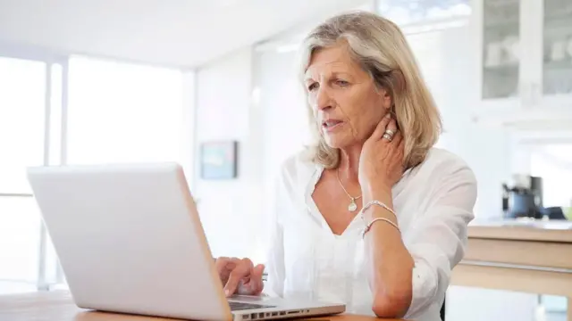 سيدة تقرأ من شاشة كمبيوتر محمول