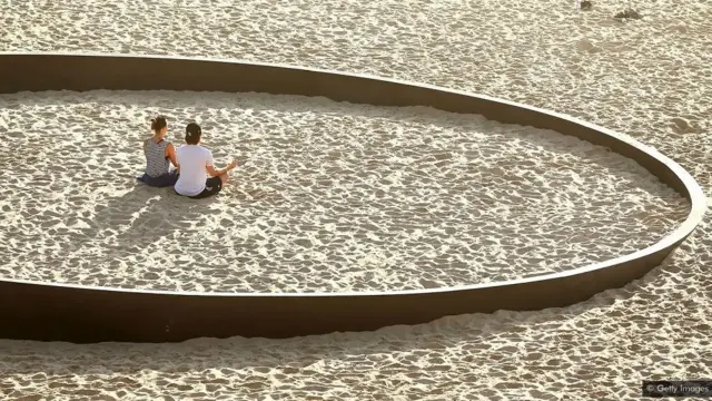 Duas mulheres na praia meditanto