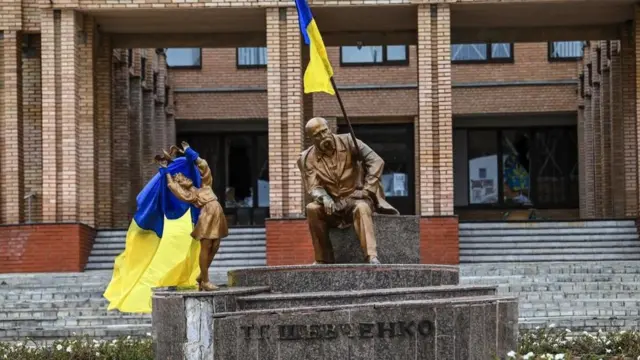 A photograph taken on September 10 , 2022, shows Ukrainian flags placed on statues in a square in Balakliya, Kharkiv region, amid the Russian invasion of Ukraine. - Ukrainian forces said on September 10, 2022 they had entered the town of Kupiansk in eastern Ukraine, dislodging Russian troops from a key logistics hub in a lightning counter-offensive that has seen swathes of territory recaptured