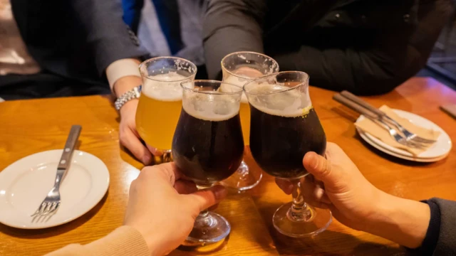 Un grupo de personas brinda con cuatro copas.