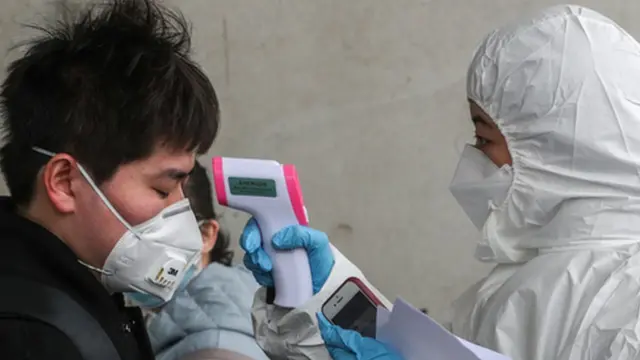 신종 코로나바이러스감염증(코로나19) 확산세가 급증하고 있는 25일 오후 중국인 유학생들이 인천국제공항 입국장을 통해 입국해 대학 관계자로부터 체온 검사를 받고 있다