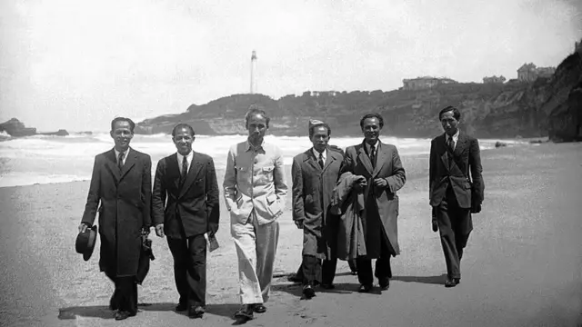 The Vietnam nationalist leader HO CHI MINH who arrived in France for a conference is being photographed on the BIARRITZ beach along with the Vietnam delegation