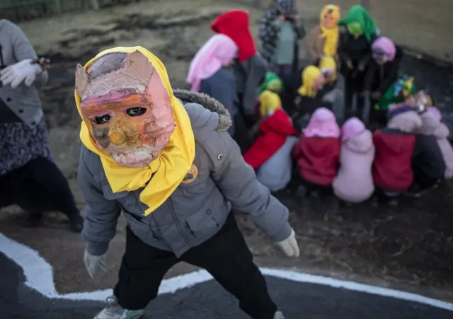 Costumed children from the local Shade performance group perform their show during the annual Brixton Burn in Johannesburg, South Africa, 28 August 2021. The annual event is run by members of the "Afrikaburn" community which is a regional event of "Burning Man" in the United States.