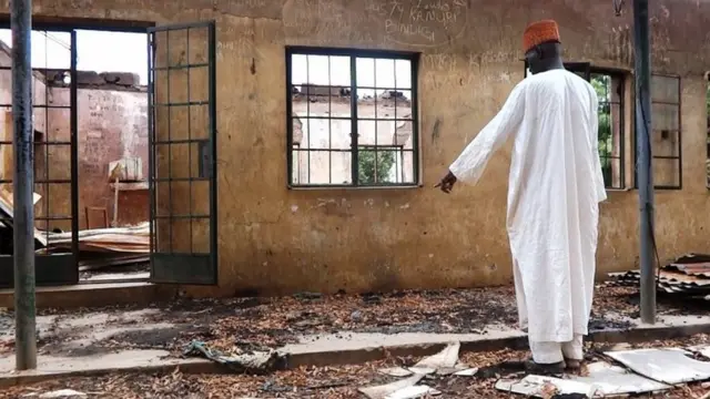 Ọkunrin kan duro ni iwaju lleewe kan ti wọn kọlu.