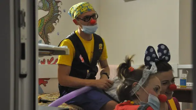 Клоуни на лікарняному ліжку, розважають пацієнтів