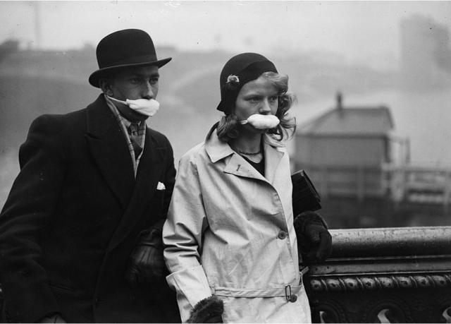Des piétons dans une rue de Londres portant des masques sur la bouche.
