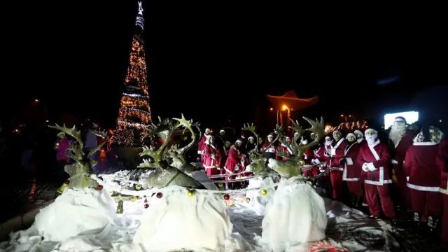 Noel baba kostümü giymiş gençler Şam'da Noel ağacının etrafından toplandılar