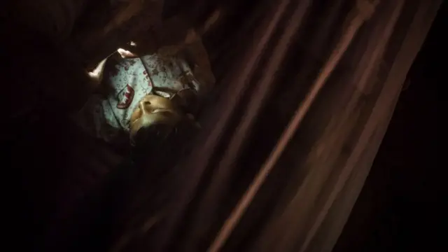 सोते वक्त स्मार्टफोन इस्तेमाल करता बच्चा