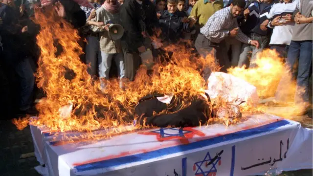 গাযায় হামাস আন্দোলনকারীরা ইসরায়েলের প্রতীকী কফিনে আগুন ধরিয়ে বিক্ষোভ প্রদর্শন করছে - ফেব্রুয়ারি ২০০১