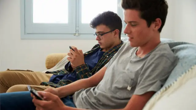 شابان يطالعان هاتفيهما