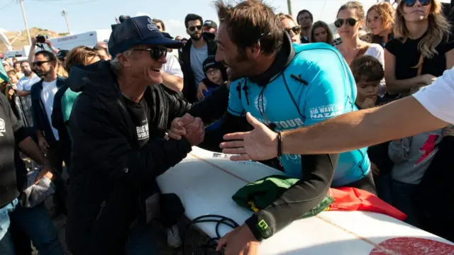 Surfista João De Macedo saluda a seguidores.