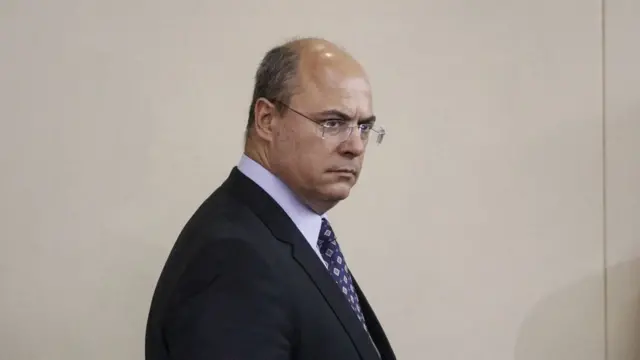 Witzel aparece em ambiente interno e de perfil