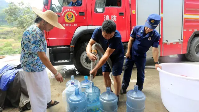 Petugas pemadam kebakaran mengantarkan air ke rumah warga akibat kekurangan air saat gelombang panas di Provinsi Hunan, Agustus 2022.