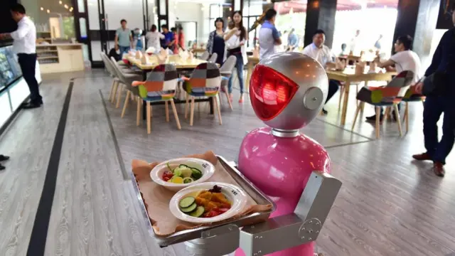 روبوت يحمل الطعام في أحد المطاعم كأنه نادل
