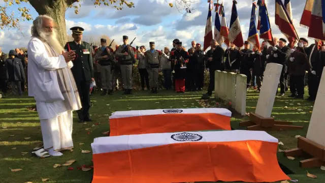 दो अज्ञात भारतीय सैनिकों का अंतिम संस्कार करते एक पुजारी