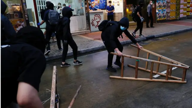 有黑衣示威者在路中央放置杂物。