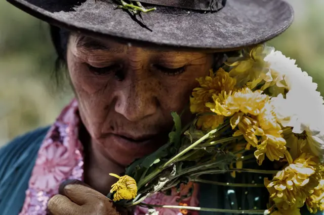 Una mujer lleva flores en memoria a sus familiares desaparecidos. (Foto: Ángela Ponce).