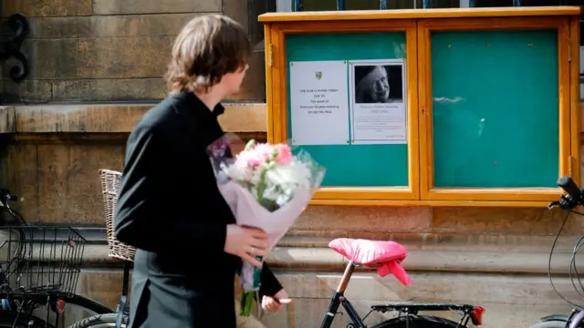 หลายคนเดินทางมาวางดอกไม้แสดงความอาลัยต่อ ศ.ฮอว์คิง ที่มหาวิทยาลัยเคมบริดจ์ ในสหราชอาณาจักร