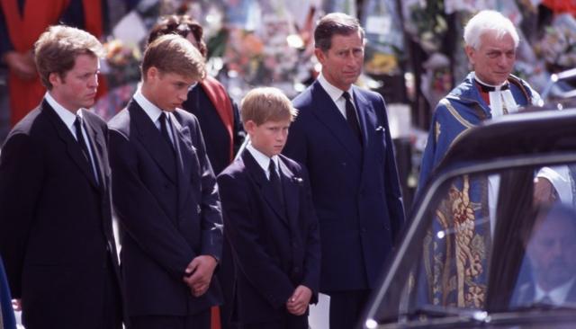 Ao lado do tio, o conde Spencer e do pai, o agora rei Charles, William e Harry caminhando atrás do caixão da princesa Diana em seu funeral em 1997
