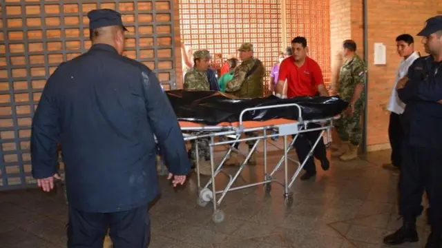 Policías trasladan el cuerpo de un miliar asesinado.