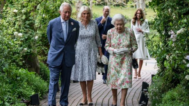 Príncipe Charles, Camila, a Rainha, William e Kate caminham em um caminho ao a livre