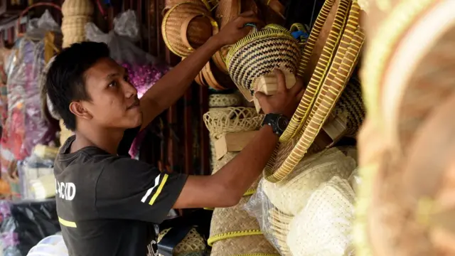 Seorang pedagang besek bambu menata barang dagangannya di sebuah kios di Jalan Jatinegara Barat, Jakarta Timur, Sabtu (10/08/2019). Sejumlah pedagang mulai menjual besek yang terbuat dari bambu untuk membungkus daging kurban saat Idul Adha.