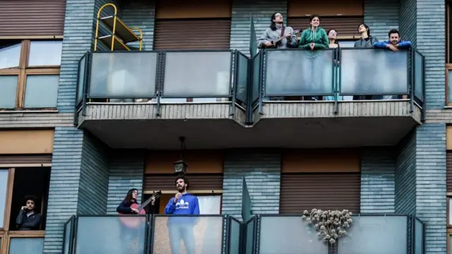 Flashmob during coronavirus isolation, musicians play at the same time from windows and balconies in Via Padua, Milan