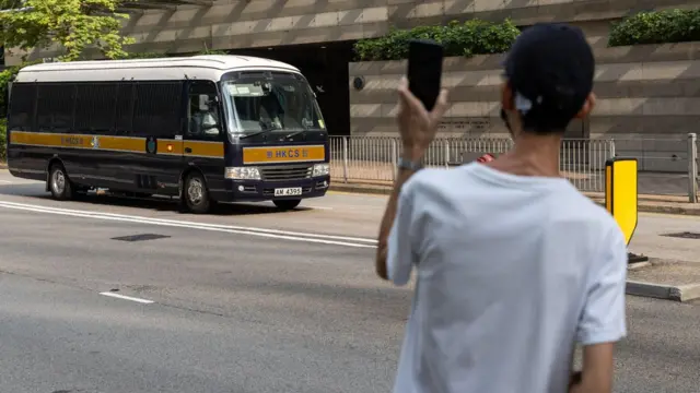 香港湾仔法院大楼外一名年轻男子举起手机电筒朝囚车挥舞（10/9/2022）
