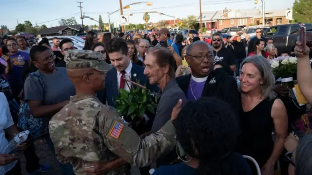 የቀብሩ ታዳሚዎች አዛውንቱን ሲያጽናኑ