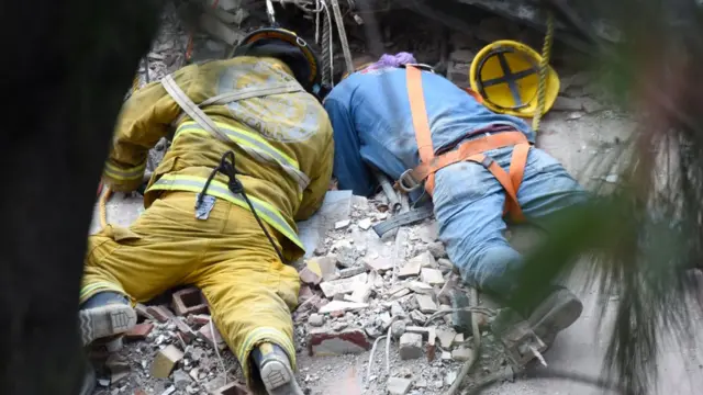 मलबे में फंसे लोगों को बचाने की कोशिश में लगे बचाव कर्मी