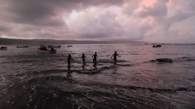 De jeunes villageois jouent dans l'océan Pacifique dans le village de Waisisi, au Vanuatu.